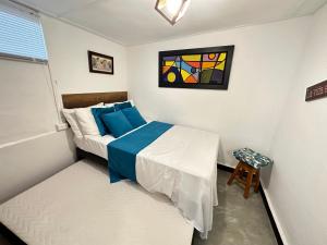 um pequeno quarto com uma cama e um quadro na parede em Casa Ancestral - Poblado - Transversal Superior em Medellín