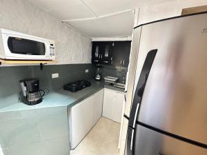 uma cozinha com um frigorífico de aço inoxidável e um micro-ondas em Casa Ancestral - Poblado - Transversal Superior em Medellín