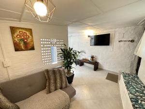 sala de estar con sofá y TV en Casa Ancestral - Poblado - Transversal Superior, en Medellín
