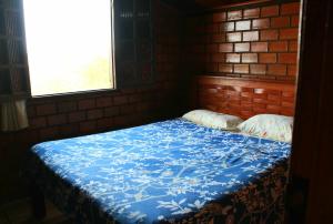 1 dormitorio con 1 cama con manta azul en Casa Aconchegante na Serra de Gravatá, en Gravatá
