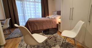 a bedroom with a bed and chairs and a table at Premium Studio Apartment - Belgrade Waterfront in Sajmište