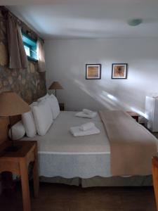カマンドゥカイアにあるPousada Pinho Bravoのベッドルーム1室(ベッド1台、タオル2枚付)