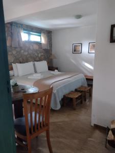 卡曼杜卡亞的住宿－Pousada Pinho Bravo，一间卧室配有一张大床和一张桌子及椅子