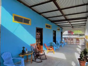 Cette chambre est dotée de chaises, de tables et d'un mur bleu. dans l'établissement Hostal Siero, à Moyogalpa