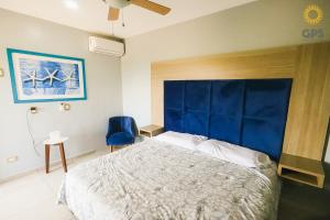 a bedroom with a large bed with a blue headboard at 3010 Habitación en Pacifika, excelente ubicación in Mazatlán