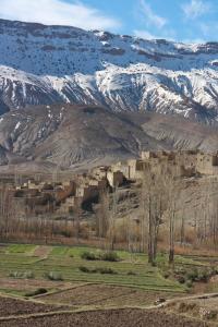 a village in front of a snow covered mountain at Auberge Palacio Sidi Hamza in Tazrouft