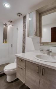 a bathroom with a white toilet and a sink at Penthouse Lujoso y moderno en el centro de Riobamba - Wanderlot Leganza in Riobamba