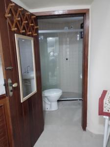 uma casa de banho com um WC, um lavatório e um espelho. em Cabana lofft 70 em Tucuns Búzios em Búzios