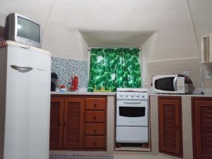 a kitchen with a white refrigerator and a microwave at Cabana lofft 70 em Tucuns Búzios in Búzios +6 photos