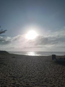 uma praia com o sol brilhando sobre a água em Cabana lofft 70 em Tucuns Búzios em Búzios