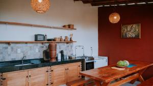 eine Küche mit einem Holztisch und einem Waschbecken in der Unterkunft Vila Corumbau Cacau in Corumbau