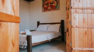 ein Schlafzimmer mit einem Bett und einem Gemälde an der Wand in der Unterkunft Vila Corumbau Cacau in Corumbau + 61 Fotos