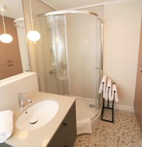 een badkamer met een wastafel en een douche bij Falcon Apartment Center 1 Warszawa Centralna in Warschau