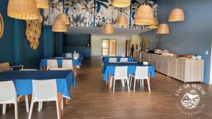jadalnia z niebieskimi stołami i białymi krzesłami w obiekcie Eco Resort Praia dos Carneiros - Flats & Bangalô - LocarHouse w mieście Praia dos Carneiros