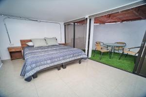 a bedroom with a bed and a table on a patio at Departamento Península con Factura in Iquique