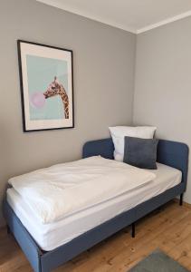 a bed in a room with a giraffe picture on the wall at FeWo Goldstück mit privatem SPA und Whirlpool in Grafenau