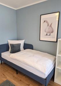 a bed in a room with a picture of a goose at FeWo Goldstück mit privatem SPA und Whirlpool in Grafenau