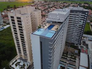 una vista aérea de un edificio alto con piscina en Flat Duo JK. Lindo e completo, en São José do Rio Preto