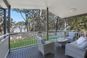 un porche con mesa y sillas de mimbre en Reflections Moonee Beach - Holiday Park en Moonee Beach