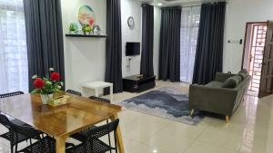 チャンルーンにあるD'Lisha Homestay Changlun/Bukit Kayu Hitam/Sintokのテーブルとソファのあるリビングルーム +20枚の写真