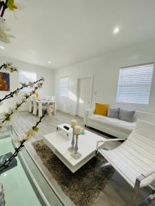 uma sala de estar com um sofá branco e uma mesa em Modern & New,Excellent Location Miami em Miami