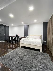 um quarto com uma cama, uma mesa e um tapete em Aainaa Villa Homestay em Pasir Mas