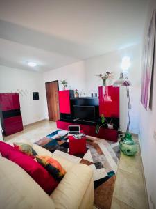 un soggiorno con divano e mobili rossi di West Sardinia Apartments a Càbras