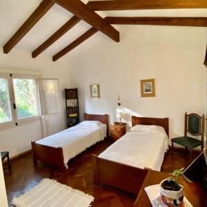 1 dormitorio con 2 camas, mesa y silla en Faraway's Bed & Breakfast en Los Cocos