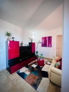 un soggiorno con divano e TV a schermo piatto di West Sardinia Apartments a Càbras