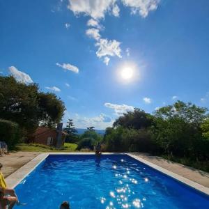 a blue swimming pool with the sun in the sky at Faraway's Bed & Breakfast in Los Cocos