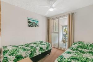a bedroom with a bed and a couch and a window at Tweed Paradise Unit 2 in Coolangatta