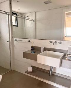 uma casa de banho com um lavatório branco e um espelho. em 415 - Rentaqui - Flat Jardins Residence Confort em São Paulo