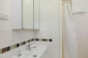 Baño blanco con lavabo y espejo en Reflections Coffs Harbour - Holiday Park en Coffs Harbour