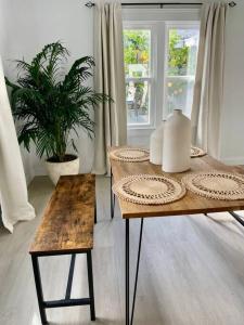 a table and bench in a room with a window at Coastal inspired apartment in downtown culver city in Los Angeles