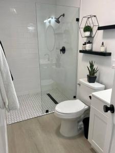 a white bathroom with a shower and a toilet at Coastal inspired apartment in downtown culver city in Los Angeles