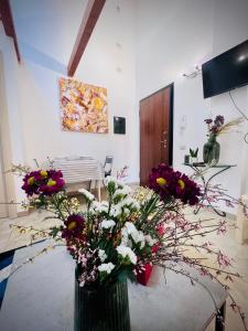 un vaso pieno di fiori su un tavolo in una stanza di West Sardinia Apartment 2 a Càbras