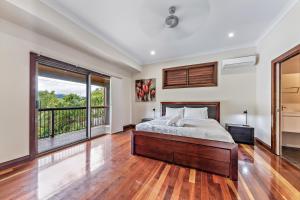 a bedroom with a bed and a large window at Seascape Paradise in Airlie Beach