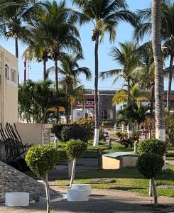 un parc avec des palmiers et un bâtiment dans l'établissement Las mejor opción Departamento Zona Diamante - Puente del Mar, à Acapulco