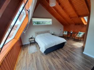 1 dormitorio con 1 cama en una habitación con suelo de madera en EL RINCON DE LÚ, en Chile Chico