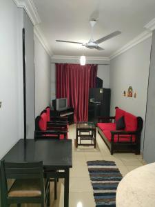 a living room with a red couch and a table at Al Dahar apartments Hurghada in Hurghada