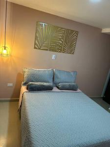 1 dormitorio con 1 cama azul y 2 almohadas en Hermoso y Cómodo Apartaestudio 703, en Medellín