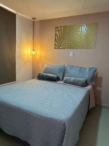 1 dormitorio con 1 cama grande con almohadas azules en Hermoso y Cómodo Apartaestudio 703, en Medellín