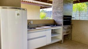 a kitchen with a sink and a stove at Village em Guarajuba in Guarajuba