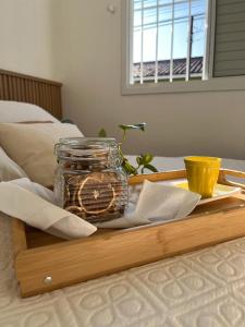 bandeja con un frasco encima de una cama en Casatempo Moradas Pelotas Quartier proximo hospital Unimed, en Pelotas