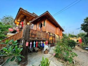 a wooden house with a balcony and a store at กิ่วลม - ชมลคอร Kiwlom - Chomlakorn, Lampang, TH in Lampang