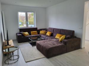 a living room with a brown couch and yellow pillows at Villa Bed & Garden in Brussels