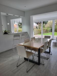 a dining room with a wooden table and white chairs at Villa Bed & Garden in Brussels