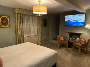 um quarto com uma cama e uma televisão de ecrã plano em The George Hotel Easingwold em Easingwold