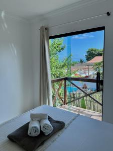 a bedroom with a bed and a view of a balcony at Maré Suítes Maragogi in Maragogi