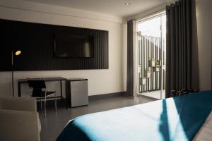 a bedroom with a bed and a table and a television at QASA by NOMAD in Arequipa